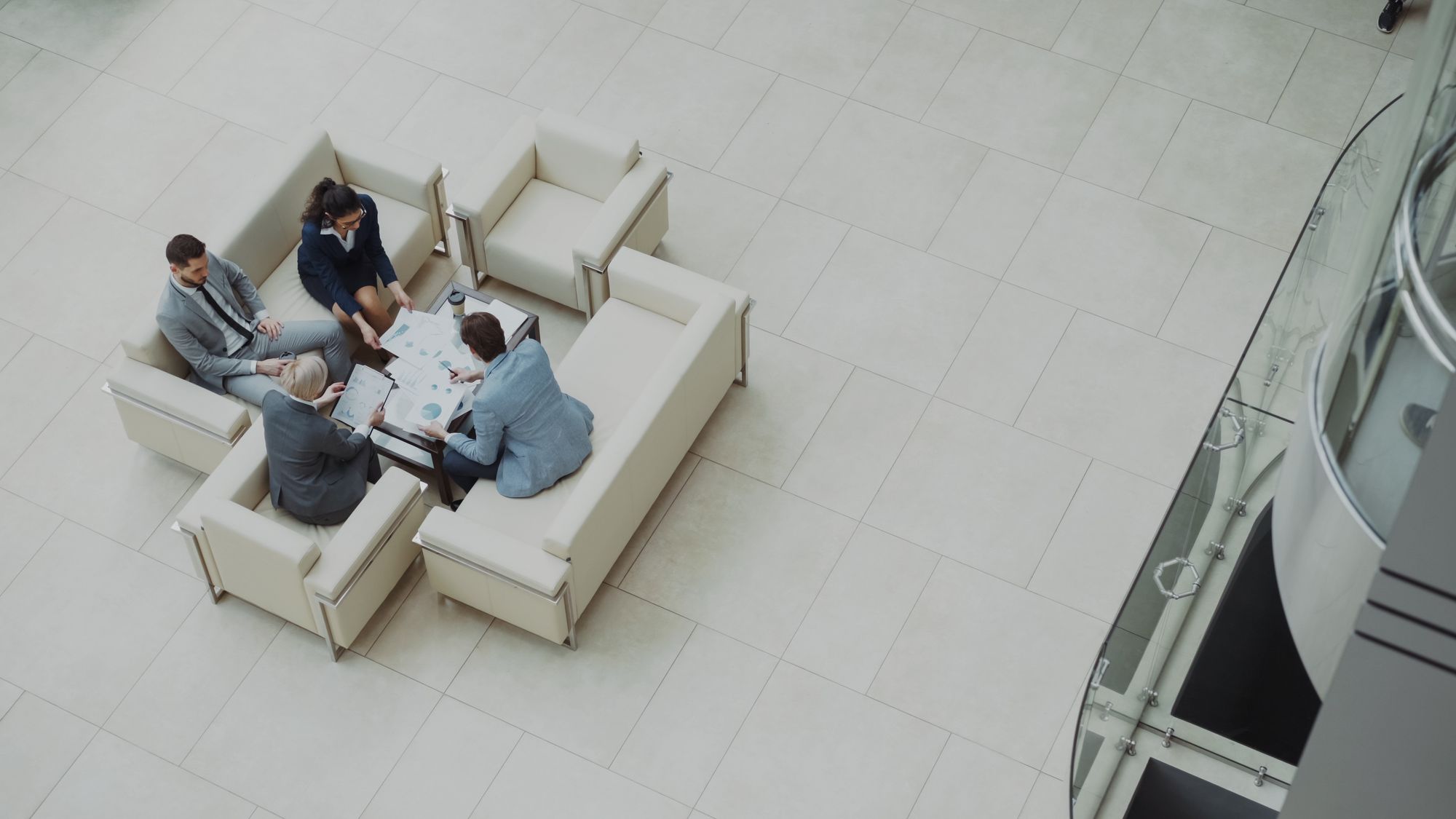 Four professionals reviewing charts and papers together around a table